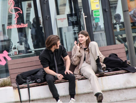 Девушка и парень беседуют на скамейке